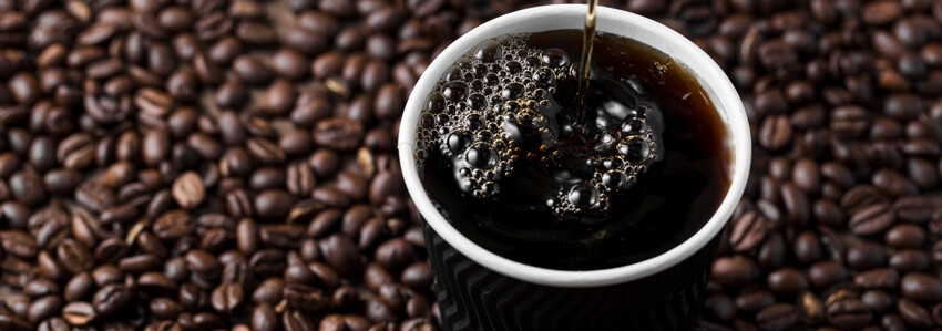 Americano with coffee beans in the background