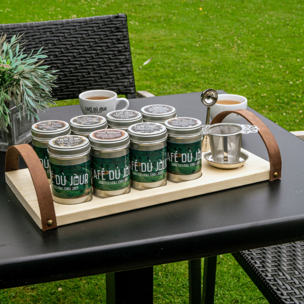 Presentation tea board with cans of tea, tea spoon and tea filter