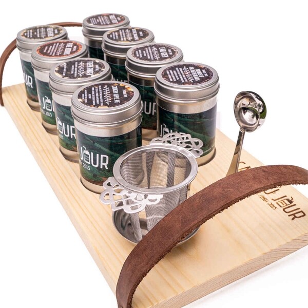 Presentation tea board with cans of tea, tea spoon and tea filter